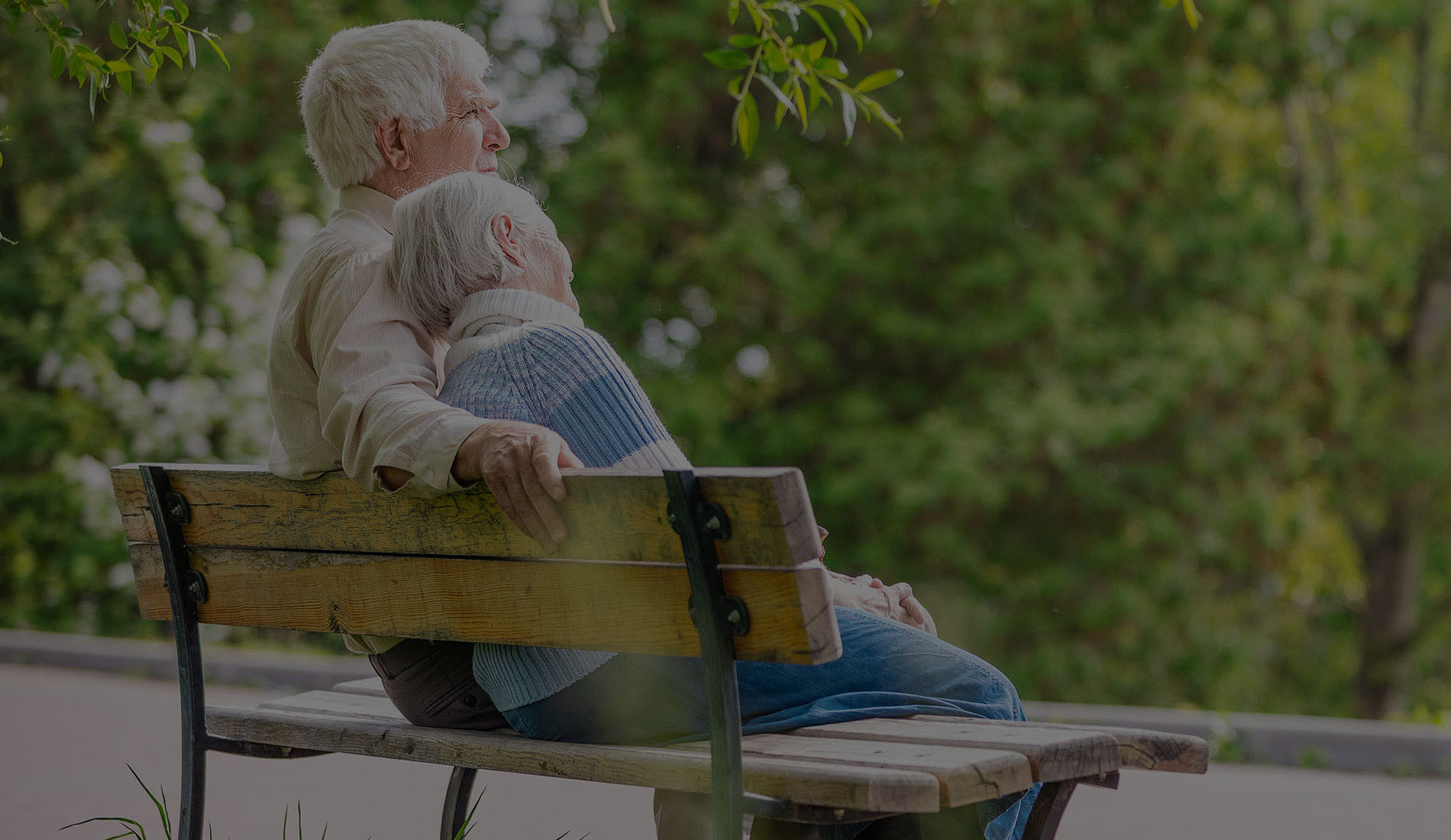 Elderly couple resting on a bench in the park